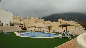 een groot gebouw met een zwembad en groen gras bij Casa Montesol in Calpe