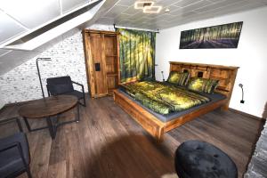 a bedroom with a large bed and a table at Ferienwohnung Odenwaldwellness in Wilhelmsfeld
