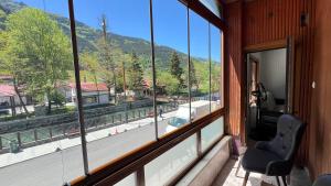 a balcony with two chairs and a view of a mountain at Lavera Home Uzungöl in Uzungöl