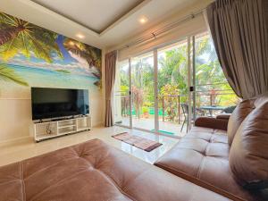 a living room with a couch and a large window at Oasis 1 Bedroom Apartment In Rawai in Phuket Town