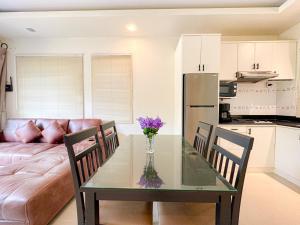 a kitchen and a table with a vase of flowers on it at Oasis 1 Bedroom Apartment In Rawai in Phuket Town