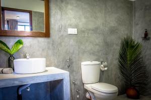 a bathroom with a sink and a toilet and a mirror at Haven Beach Hiri - Hiriketiya in Hiriketiya +85 photos