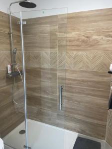 une douche avec une porte en verre dans une salle de bain dans l'établissement l'Esquirou, à Malemort-du-Comtat