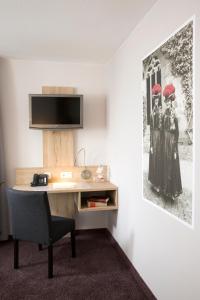 um escritório com uma secretária com um monitor e uma cadeira em Hotel Rössle em Alpirsbach
