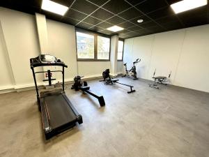 einen Fitnessraum mit mehreren Heimtrainern und einem Laufband in der Unterkunft Studio 63 Rénové et Équipé - Nancy Brabois proche CHRU,CESI,FAC in Vandoeuvre-lès-Nancy