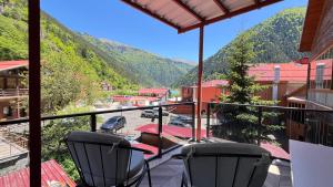 a balcony with two chairs and a view of a mountain at Lavera Home Uzungöl in Uzungöl