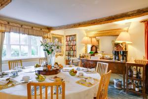 a dining room with a table and a kitchen at Hollamoor Farm in Barnstaple
