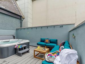 a patio with a hot tub and a blue couch at 4 Bed in Newquay 90069 in Newquay +25 photos