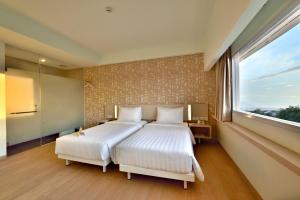 Ένα ή περισσότερα κρεβάτια σε δωμάτιο στο Whiz Prime Hotel Sudirman Cilacap