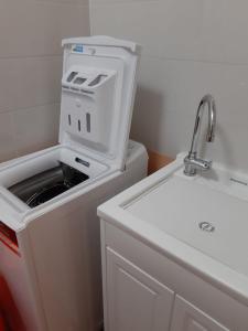 a washing machine in a bathroom with a sink at DUE PASSI dal MARE in Cittadella del Capo