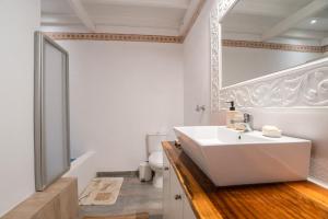 a bathroom with a white sink and a toilet at Maggano Paros Apartments 2 in Angairiá +18 photos