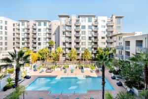an apartment complex with a swimming pool and palm trees at Blueground Santa Clara 2bd apartment SFO-1771 in Milpitas