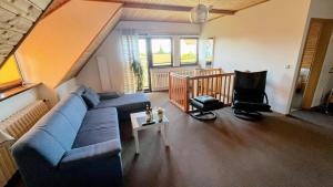 a living room with a blue couch and a chair at Ferienwohnung Fam Brunk in Altefähr +11 photos