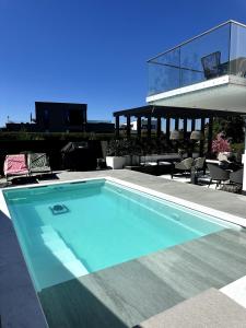 a swimming pool in front of a house at Luxury Villa with Heated Pool & Sea View Your Private Paradise on the Norwegian Coast in Kristiansand