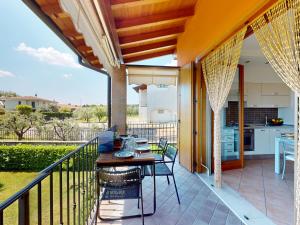a patio with a table and chairs on a balcony at Adeline Garda Nest by Bookinggardalake in Raffa