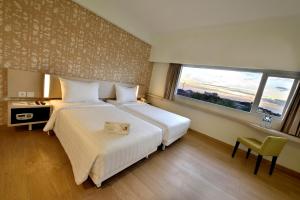 Ένα ή περισσότερα κρεβάτια σε δωμάτιο στο Whiz Prime Hotel Sudirman Cilacap