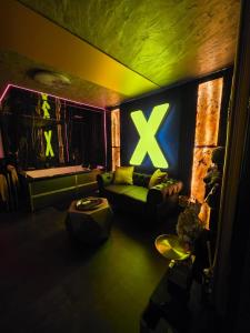 a living room with a couch and a x sign on the wall at eroXens in Saint-Amand-les-Eaux