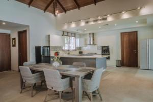 Ban Thalat Choeng ThaleにあるLuxury 3BR Villa, Private Pool, Gym & Jacuzziの木製のテーブルと椅子のある広いキッチン