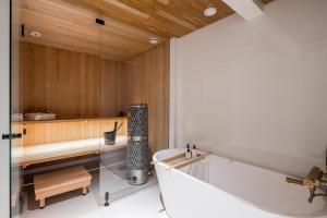 a bathroom with a bath tub and a sink at Scandinavian Deluxe House With Private Sauna at Kamppi in Helsinki