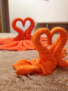 アドレルにあるU Rity Guest Houseのベッド上のオレンジ白鳥の形をしたタオル2枚