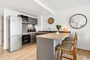 a kitchen with a counter and a refrigerator at Alamanda 114 - 2 bedroom apartment with OceanView in Orient Bay +32 photos