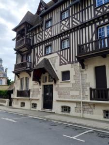 Un edificio blanco y negro al costado de una calle. en Mer et Style, en Cabourg