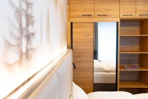 a bedroom with a mirror next to a bed at Apartment 1 - Schmiedefeld - klein und fein in Schmiedefeld am Rennsteig +27 photos