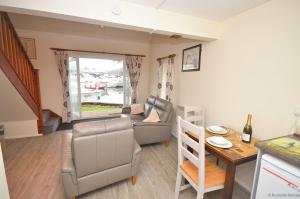 a living room with a couch and a table at Cavell - sleeps 2 people right in the heart of Wroxham on the Norfolk Broads in Wroxham