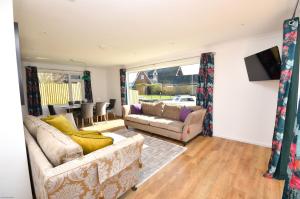 a living room with two couches and a tv at Coots - beautiful property in the heart of Wroxham sits on the waterside in Wroxham