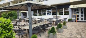 a group of tables and chairs in front of a building at Bach's Restaurant Bar Hotel in Erkrath