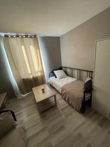 a bedroom with a bed and a coffee table at Studio spacieux in Creil
