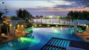 a large swimming pool with a view of the ocean at Studio Seaview Jomtien floor12 23sqm in Jomtien Beach