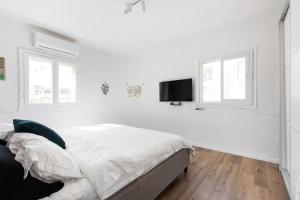 Televisyen dan/atau pusat hiburan di Artistic 2BR Apt w Balcony in Florentin Center by Sea N' Rent