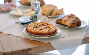 a table topped with plates of pastries and croissants at Agriturismo Dalla Libera in Valdobbiadene