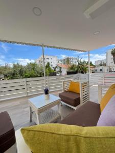 a living room with a couch and an umbrella on a roof at Makenzy Mermaid 2 Bedroom Apartment in Larnaka
