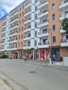 an empty street in front of a large apartment building at S&S City Apartment in Shkodër +9 photos