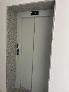 an elevator door with a clock on top of it at S&S City Apartment in Shkodër