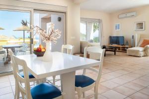 a living room with a white table and chairs at Dreamview Villa in Agios Nikolaos