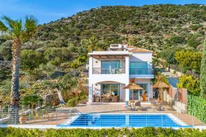 a villa with a swimming pool and a mountain at Dreamview Villa in Agios Nikolaos