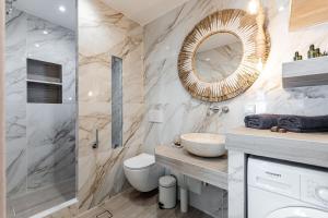 a bathroom with a sink and a toilet and a mirror at Ruby of Naxos Residences in Kastraki