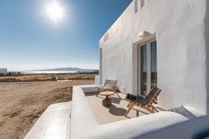 two chairs and a table next to a building at Ruby of Naxos Residences in Kastraki