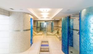 La salle de bains est pourvue de murs bleus et d'une douche à l'italienne. dans l'établissement Villa Alina Medical SPA, à Polanica-Zdrój