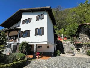 a large white house with a stone driveway at Raggio di Sole Villa in Oggebbio