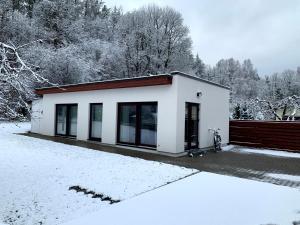 a small white house in the snow at Mäekalda Guesthouse Garden Villa with private sauna in Rakvere