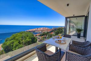 a balcony with a table and chairs and the ocean at La Dolce Villa in Dubrovnik