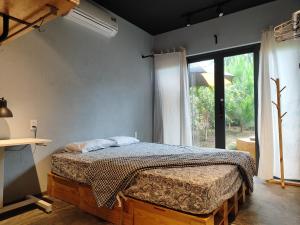 a bedroom with a bed in a room with a window at MAI HOTAY Lakeside Highland Retreat Homestay in Ðức Lập