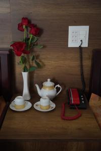 a table with two cups and a teapot and a telephone at KHÁCH SẠN ĐẾ VƯƠNG in Cao Lãnh