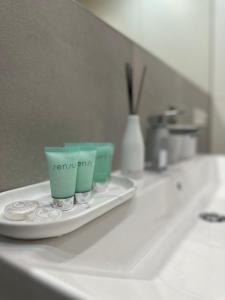 two cups on a plate on a bathroom sink at Apartament Dwie Sosny Patrycja in Ustronie Morskie