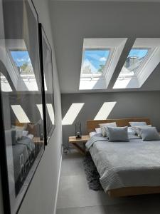 two beds in a bedroom with skylights at Apartament Dwie Sosny Patrycja in Ustronie Morskie
