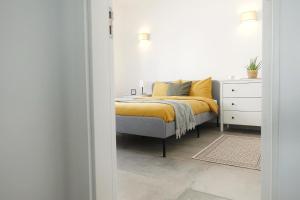 a bedroom with a bed with a yellow blanket at Endless Ocean - Praia da Luz in Luz